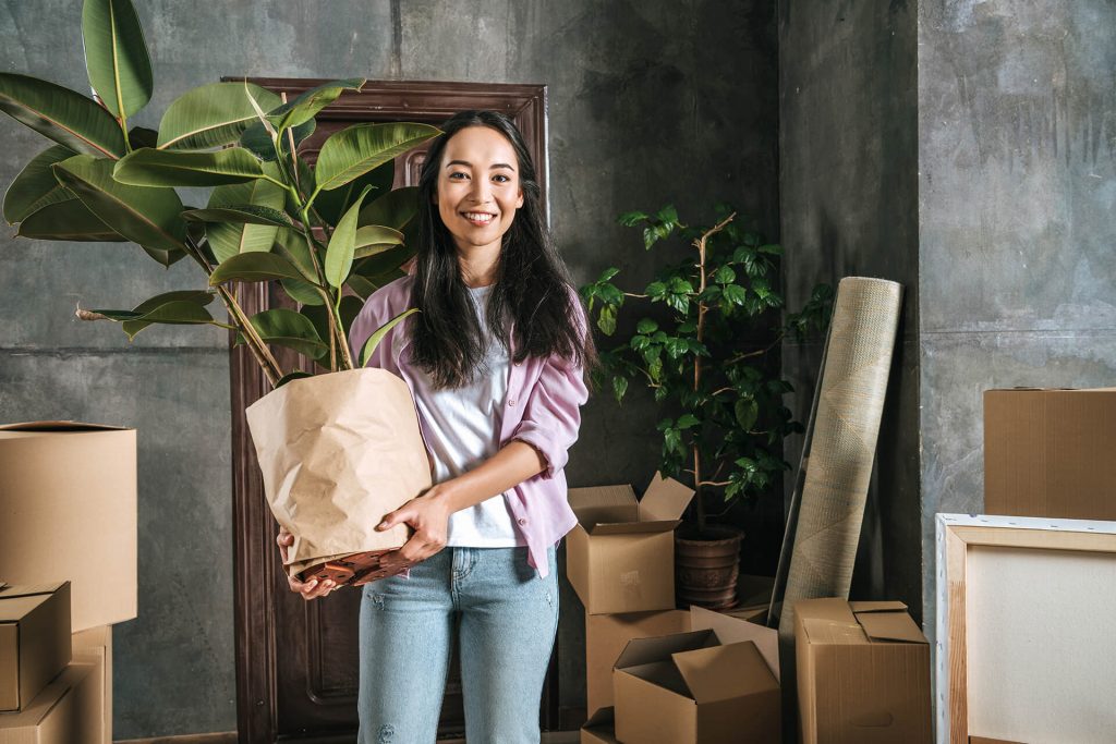 woman holding a plant during her house move